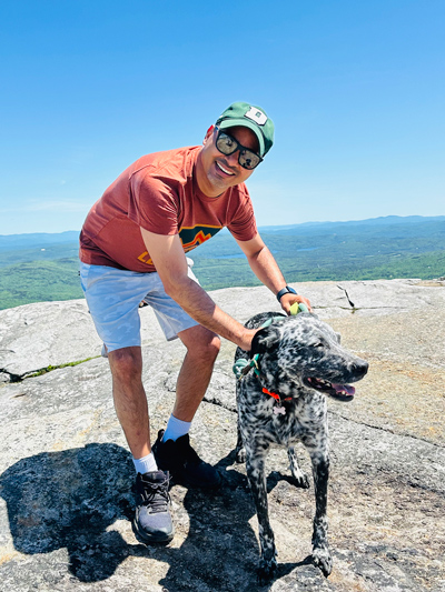 Dipak Niroula enjoying a moment with a dog brought by visitors to Cardigan Mountain (2024)
